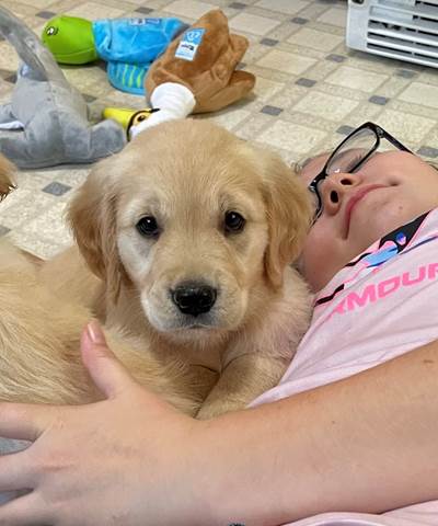 A child lying on a tile floor with a dog

Description automatically generated